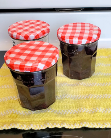 homemade jam cooling on a yellow towel