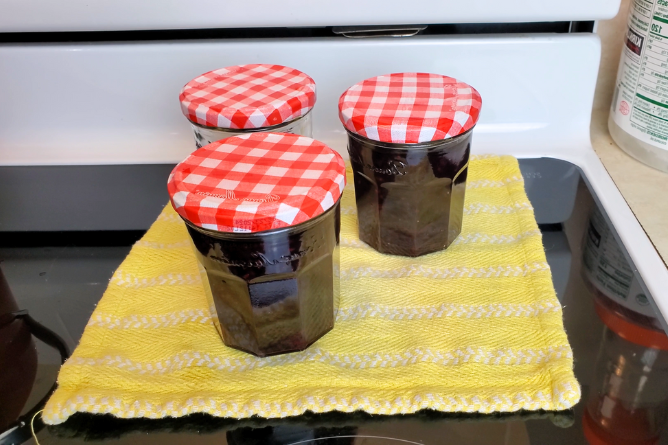 homemade jam cooling on a yellow towel