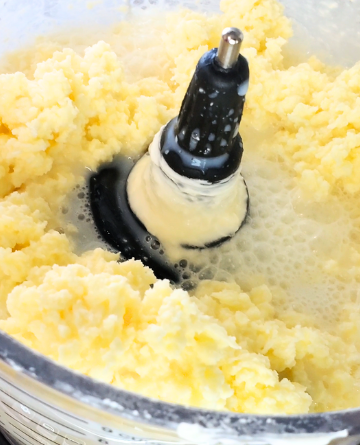 close up of curds of butter & liquid buttermilk in a ninja food processor