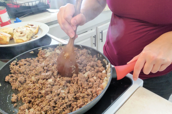 woman stirring and browning hamburger meat