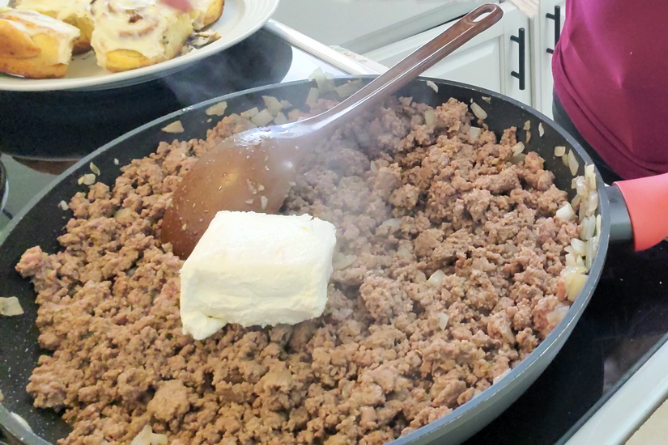 cream cheese on top of finely chopped hamburger meat in a large skillet