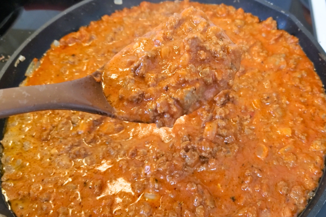 large brown spoon filled with homemade pasta sauce