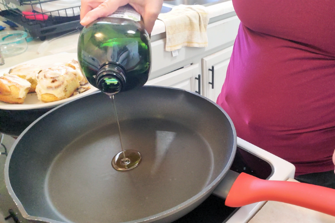 woman pouring avocado oil into a large skillet